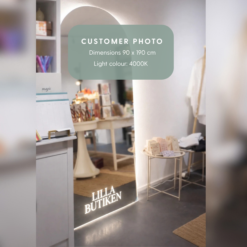 A retail interior scene with a large arched mirror on the wall, showing a boutique display and clothing rack. The mirror has a logo on the bottom reading "LILLA BUTIKEN". A translucent green label reads 'CUSTOMER PHOTO' with dimensions and light color details.